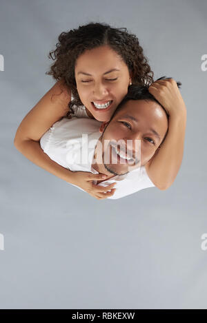 Young woman obsessed with man above top view on gray studio background Stock Photo