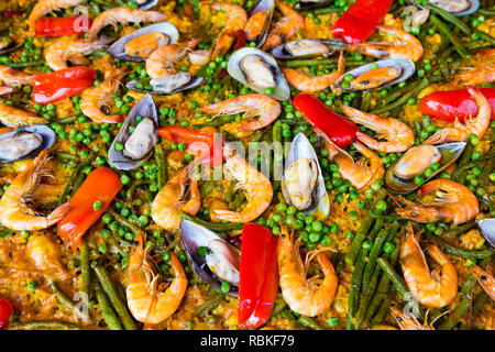Ingredients cooking in a traditional Spanish paella recipe. Paella is a traditional Valencian rice dish and is served hot. Stock Photo