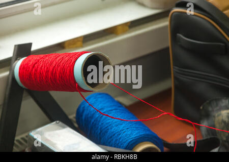 Two big bobbins with large mating colored threads in the studio fot interior design  on the table Stock Photo