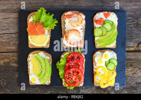 Of different sandwiches on the old wooden background. Top view. Flat lay. Stock Photo