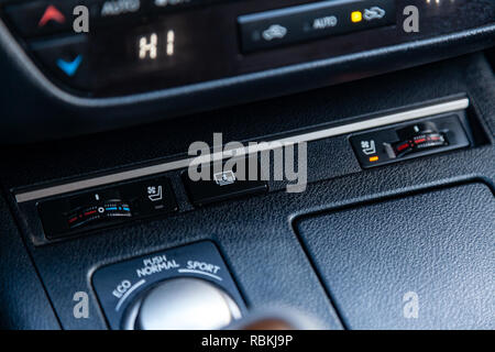 The central control console on the panel inside the car close-up buttons climate control and heated seats in black and gray. Stock Photo