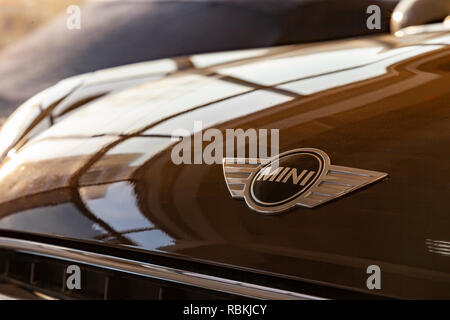 Novosibirsk, Russia - 08.01.2018: A close-up emblem with the word “mini” in metallic chrome with black color on a cooper shining brown car hood as a s Stock Photo