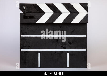 Clapper for indicating the beginning of a film or video clip made of wood and painted black and white with stripes in the closed form on a white isola Stock Photo