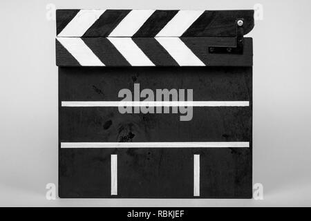 Clapper for indicating the beginning of a film or video clip made of wood and painted black and white with stripes in the closed form on a white isola Stock Photo