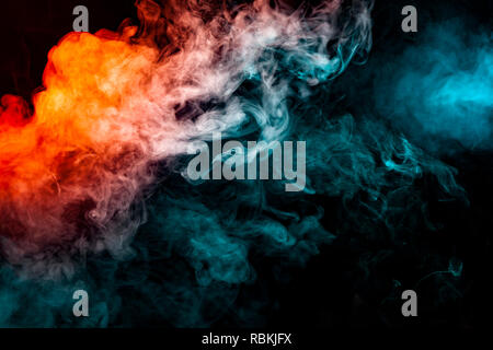 Dynamic clouds of multi-colored smoke of blue gray and orange on a black background smoothly flow with colorful waves, drawing isolated an column of s Stock Photo