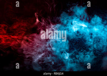 Dynamic clouds of multi-colored smoke of blue gray and orange on a black background smoothly flow with colorful waves, drawing isolated an column of s Stock Photo