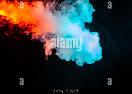 Swirling insulated colored smoke: blue, red, orange, pink; Scrolling on a black background in the dark close up. Concept design wallpaper. Stock Photo