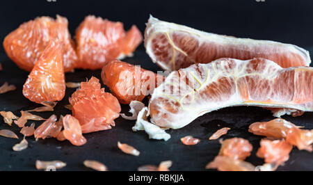 Pomelo with red pulp in front of dark background Stock Photo