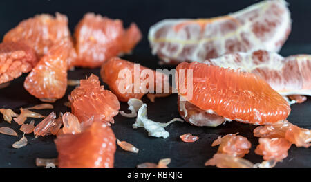 Pomelo with red pulp in front of dark background Stock Photo