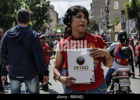 Caracas, Miranda, Venezuela. 10th Jan, 2019. A woman seen with a placard on one of the avenues in downtown Caracas to showing her support.Venezuelan President Nicolas Maduro started a second term, defying critics in the United States and Latin America who called him an illegitimate usurper of a nation where economic chaos has wrought a humanitarian crisis. The National Assembly calls the Maduro government a ''dictatorship and usurpation of power.'' Currently Venezuela is experiencing its worst economic crisis with an inflation rate of over 1,000,000% (Credit Image: © Roman Camacho/SOPA Im Stock Photo