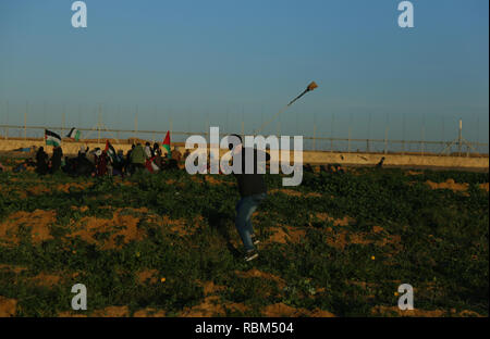 January 11, 2019 - Gaza, ???? ???????/????, Palestine - A Palestinian demonstrator seen using a slingshot to fire stones at the Israeli troops during the protest.Palestinians clashed with Israeli forces during protests on the wall between Gaza and Israel east of Khan Yunis. Credit: Yousef Masoud/SOPA Images/ZUMA Wire/Alamy Live News Stock Photo