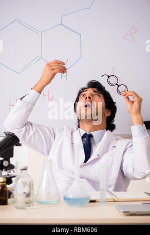 Young funny chemist in front of white board Stock Photo