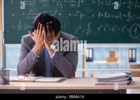 Young handsome math teacher in classroom Stock Photo