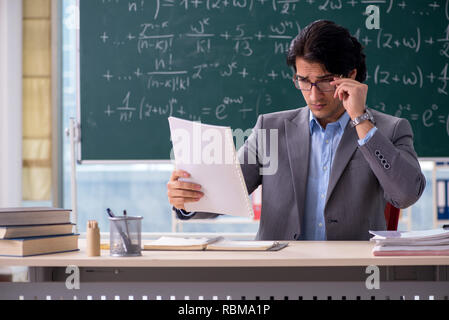 Young handsome math teacher in classroom Stock Photo