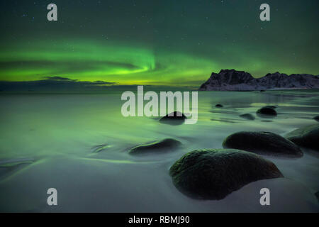 The aurora borealis over Uttakleiv beach on the Lofoten in northern Norway in winter. Stock Photo