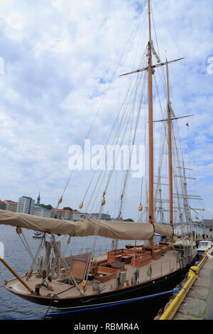 A wooden sailboat docks at the Hanseatic wharf in Bergen harbour, Norway. Stock Photo