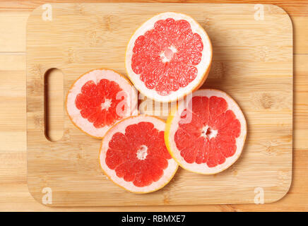 sliced grapefruit on a wooden kitchen Board. the view from the top Stock Photo