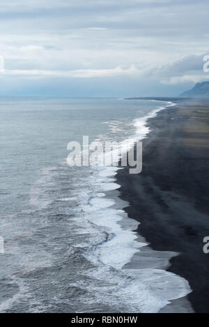 aerial view of endless coastline with surge and dark beach Stock Photo