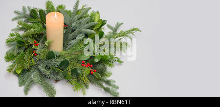 A circle of branches of different fir varieties. Green and blue Nordmann fir branches, coniferous branches and holly (Ilex) lie on white paper backgro Stock Photo