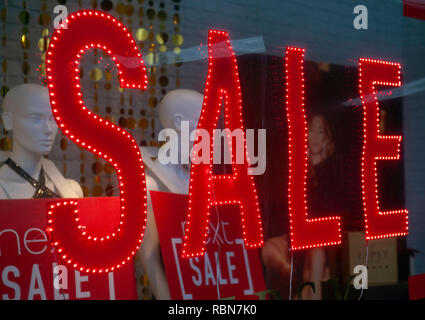 Red neon Sale sign in shop window Stock Photo