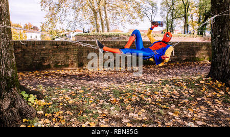 Lucca, Italy, 03/11/2018: Cosplayer dress by Spider Man performs in the park of Lucca during carnival festivities Stock Photo