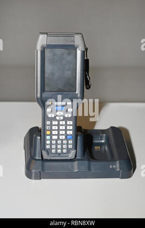 Handheld Laser Barcode Scanner Reader at Charger Dock Stock Photo