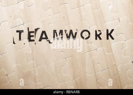 Teamwork word stamped on a wooden puzzle. Stock Photo