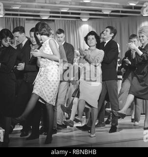 Dancing in the 1960s. The dance Hully Gully is being made popular and here are men and women dancing the new craze. Hully Gully was a type of unstructured line dance and consisted of a series of steps and was relatively simple and easy to execute. Hully Gully can be seen performed by actor John Belushi in the film Blues Brothers. Stock Photo