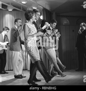 Dancing in the 1960s. The dance Hully Gully is being made popular and here are men and women dancing the new craze. Hully Gully was a type of unstructured line dance and consisted of a series of steps and was relatively simple and easy to execute. Hully Gully can be seen performed by actor John Belushi in the film Blues Brothers. Stock Photo