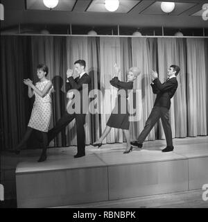 Dancing in the 1960s. The dance Hully Gully is being made popular and here are men and women dancing the new craze. Hully Gully was a type of unstructured line dance and consisted of a series of steps and was relatively simple and easy to execute. Hully Gully can be seen performed by actor John Belushi in the film Blues Brothers. Stock Photo