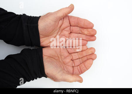 Two hands of an old man cupped in anticipation of receiving something Stock Photo