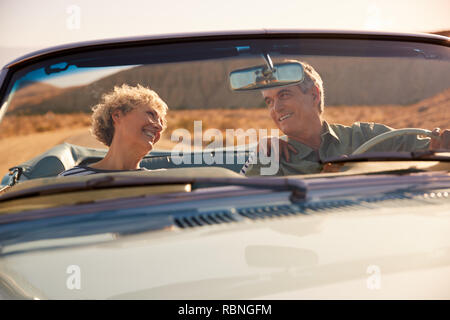 Senior couple on a US road trip, seen through car windscreen Stock Photo