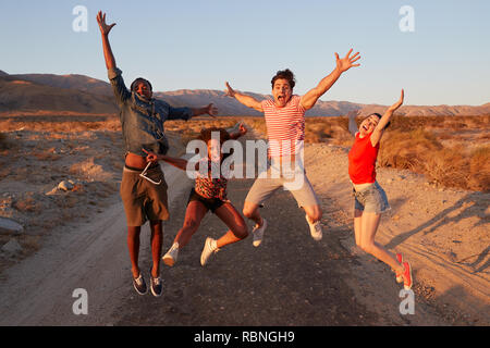 Young adult friends having fun jumping in the desert Stock Photo