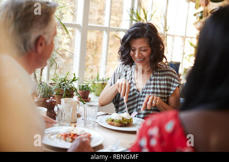 White adult woman eating with friends at a cafe, close up Stock Photo