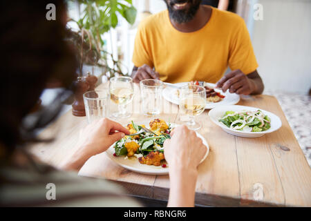 Couple eating at restaurant, over shoulder view, mid section Stock Photo
