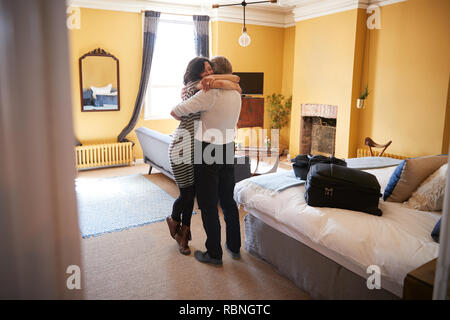 Mature couple embracing in hotel room, back view full length Stock Photo