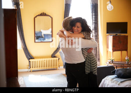 Middle aged couple embracing in their hotel room, close up Stock Photo