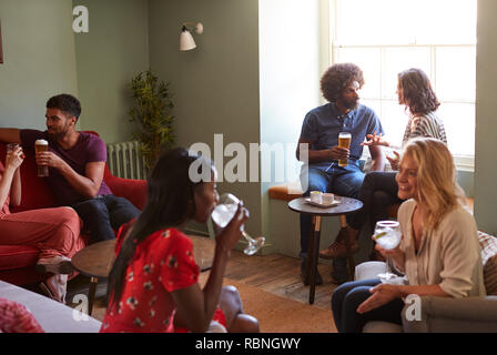 A group of people in a pub drinking and talking Stock Photo