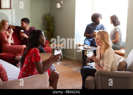 Two female friends having a drink, talking in a pub Stock Photo