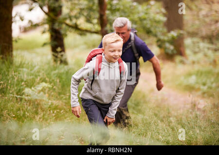 Close up of pre-teen boy hiking with his grandfather in a forest, selective focus Stock Photo
