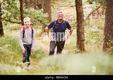 Grandfather and grandson taking a break while hiking in a forest, selective focus Stock Photo