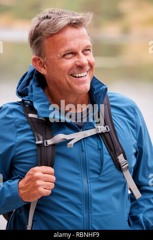 Adult man on a camping holiday looking away smiling, close up, Lake District, UK Stock Photo
