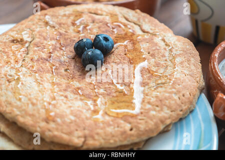 Vegan Oat Pancakes with honey and blueberries. On the table with close up view Stock Photo