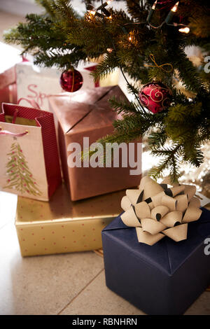Gifts arranged under a decorated Christmas tree, close up Stock Photo