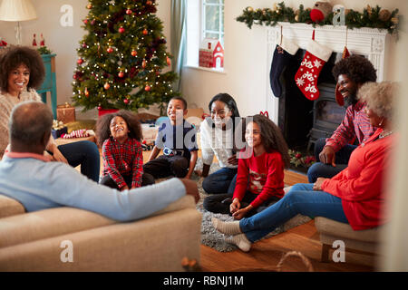 Multi Generation Family Sitting In Lounge At Home On Christmas Day Stock Photo