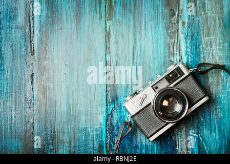 Vintage photo camera on grunge blue wooden background with copyspace. Stock Photo