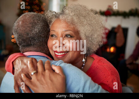 Senior Couple Hugging As They Celebrate Christmas At Home Together Stock Photo