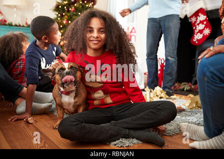 Portrait Of Girl With Pet French Bulldog Celebrating Family Christmas At Home Together