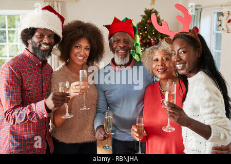 Portrait Of Parents With Adult Offspring Making A Toast With Champagne As They Celebrate Christmas Together Stock Photo