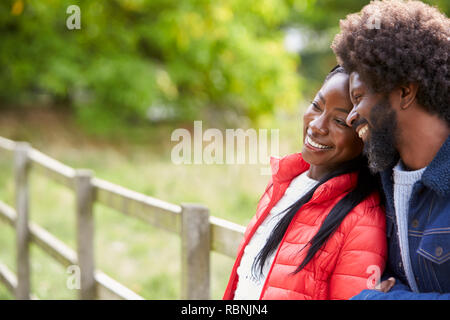 Black adult woman leaning on the shoulder of her boyfriend, standing in the countryside, close up Stock Photo